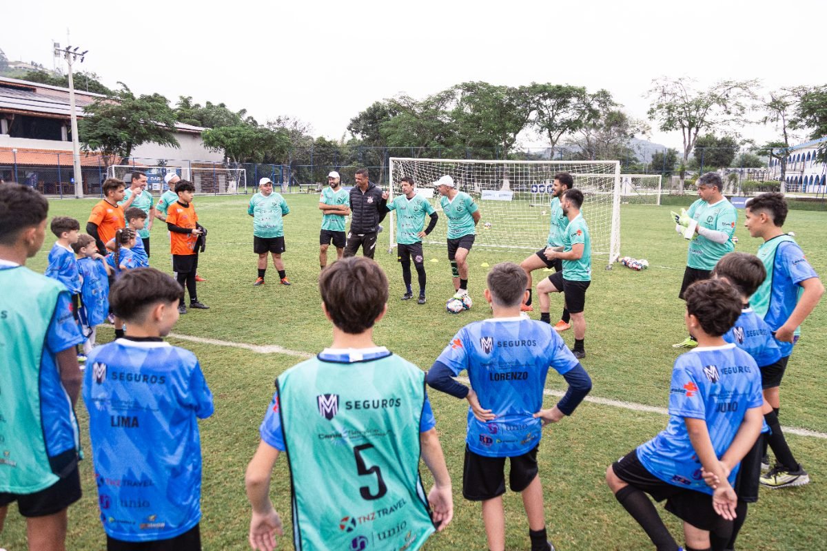 Atletas e lendas em círculo no meio do campo